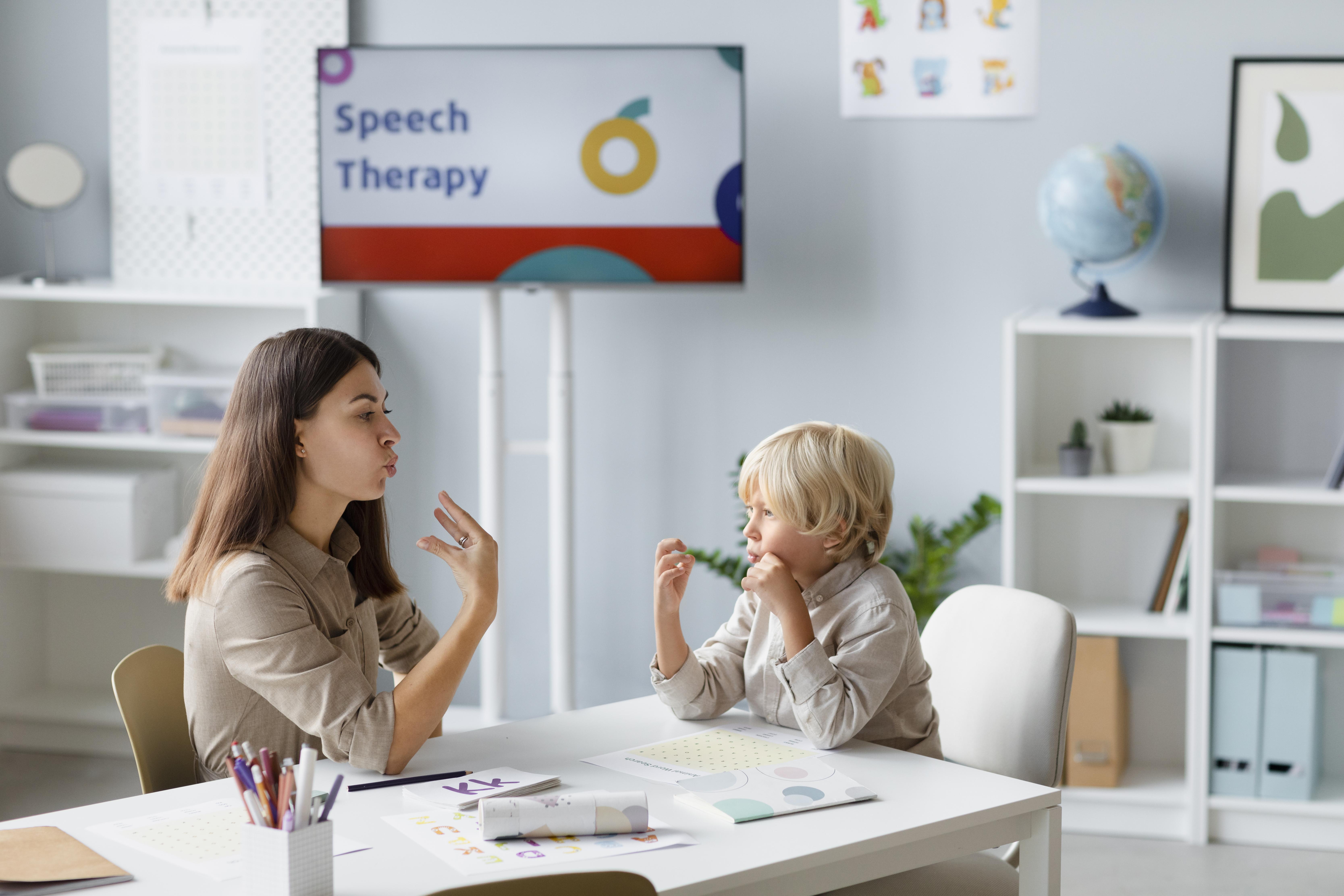 woman-doing-speech-therapy-with-little-blonde-boy